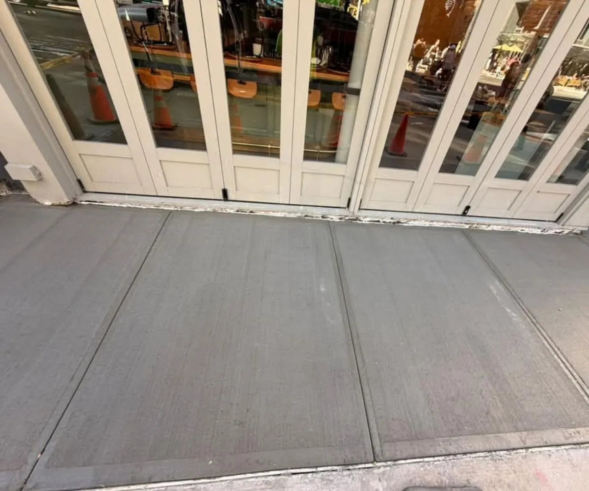 Newly replaced concrete sidewalk slabs outside 1477 2nd Avenue in Manhattan after sidewalk repair work.