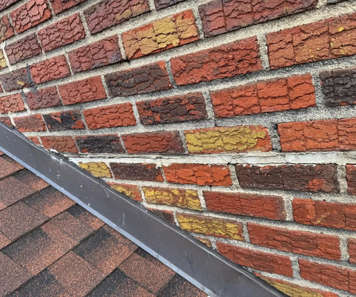 Repointed mortar joints along the existing brickwork near roof flashing at 1947 7th Ave in Manhattan.