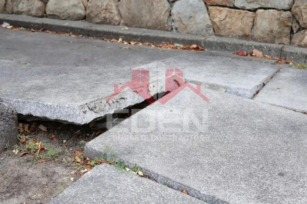 Damaged concrete sidewalk in new york city showing cracks and uneven slabs that can lead to sidewalk violations