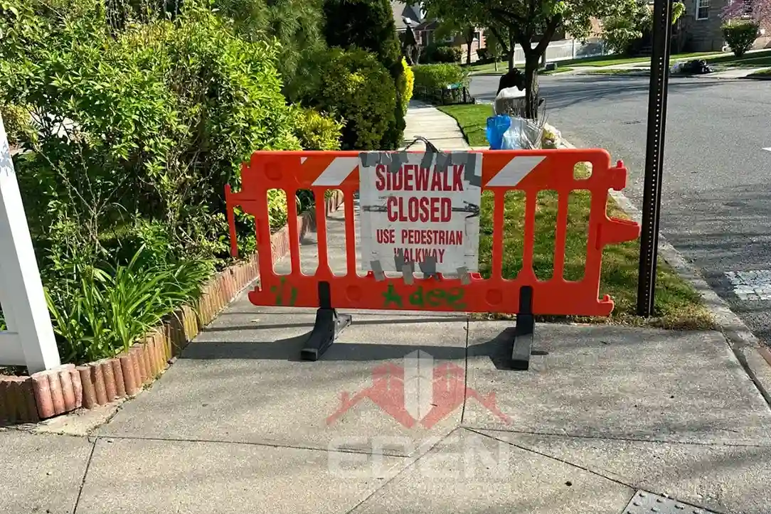 Damaged sidewalk in new york city with cracks and uneven slabs that can lead to dot sidewalk violations.